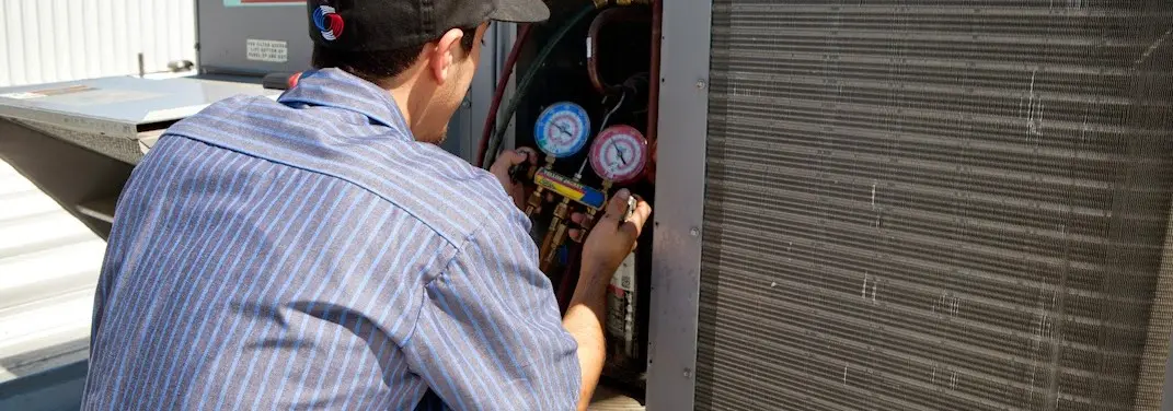 HVAC technician servicing a condenser unit in Upper Providence